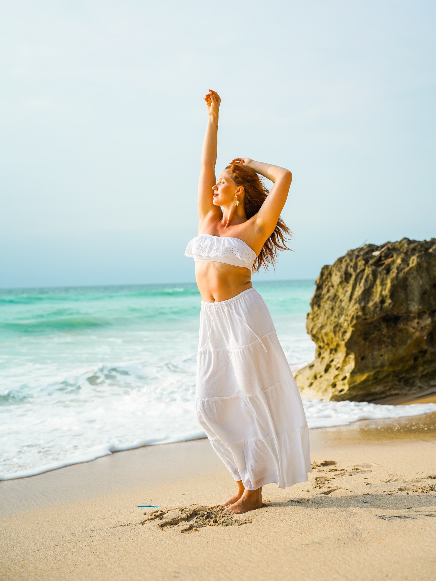Marit dancing in a white skirt, arms raised