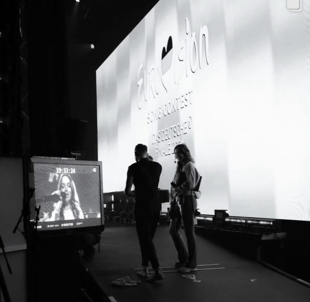 Black-and-white shot of two figures in front of an LED wall