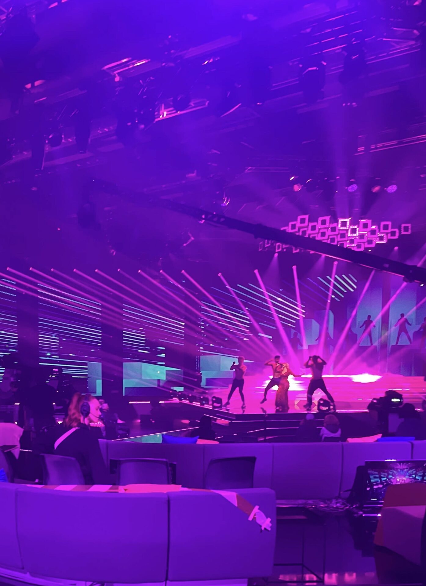 Wide view of a show floor lit in purple
