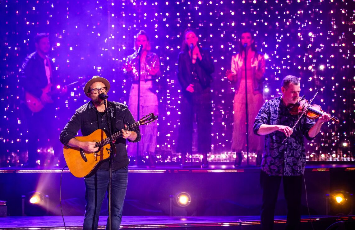 Band on stage under fairy lights